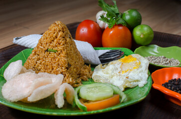 Indonesian Fried Rice with Vegetables and Side Dishes on Green Plate