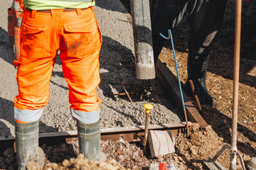 Concreter using concrete pump to pour wet concrete at building site