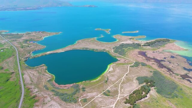 Aerial view of a tropical island with white sand beaches and volcanic features, captured by drone. Chayeri Island, Sevan, Armenia 