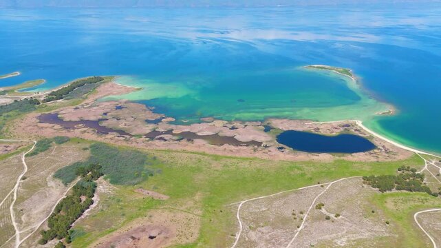 Aerial view of a tropical island with white sand beaches and volcanic features, captured by drone. Chayeri Island, Sevan, Armenia 