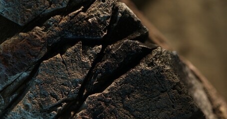 Close-up of layered fractured rock with earthy colors and moody lighting