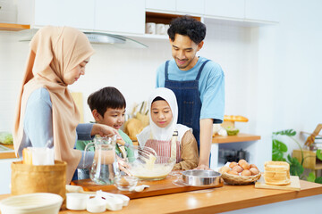 Asian muslim woman and lovely children are preparing and cooking in the kitchen.
