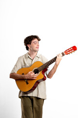 Obraz premium Young latin man, happy, playing a guitar on white background
