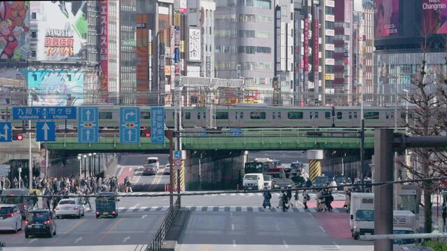 SHINJUKU,TOKYO,JAPAN : 15 Feb 2025 : Crowd of people at zebra crossing near Kabukicho downtown area. Buildings, train and street traffic.