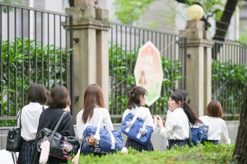 In early June in Pudong, Shanghai, seven Japanese high school girls in summer uniforms walk...