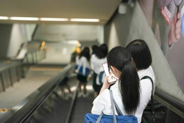 In early June in Pudong, Shanghai, seven Japanese high school girls in summer uniforms ride the...