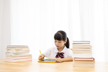 A Chinese little girl is drawing on a drawing board