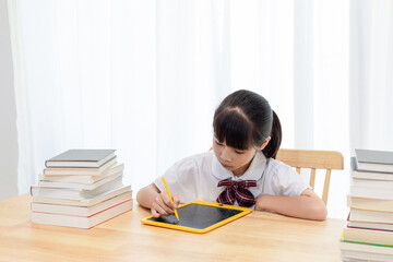 A Chinese little girl is drawing on a drawing board