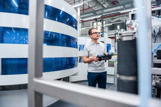 Engineer in a production hall operating machinery