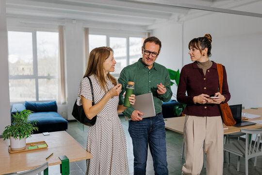Colleagues walking and talking in a modern eco-friendly office