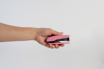 Pink stapler in hand on white background