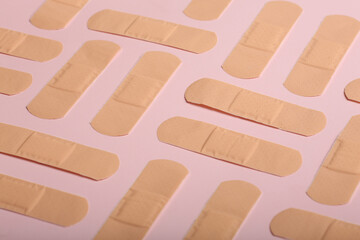 Adhesive bandage plaster on on a coloured background, the concept of protection