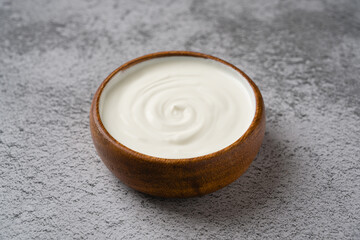 Top view of yogurt in bowl on grey stone table. Healthy eating concept