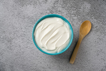 Top view of yogurt in bowl on grey stone table. Healthy eating concept