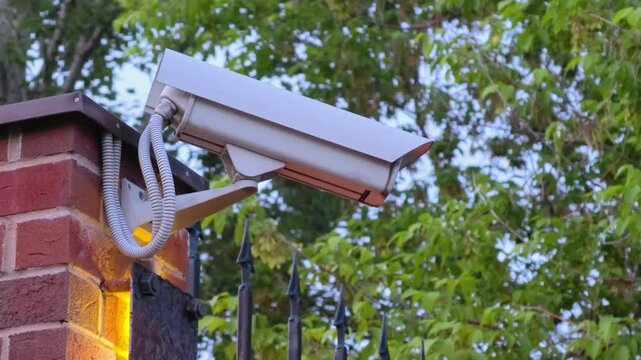 Security camera on the wall. Security camera scanning the street in city. 
