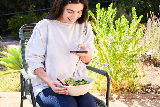 Woman taking a photo of her lunch outside