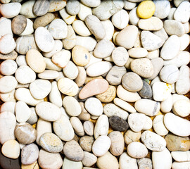 Top view of different offwhite tones and shapes of natural stones or use as a background texture.