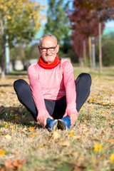 Senior man stretching on the grass during outdoor exercise