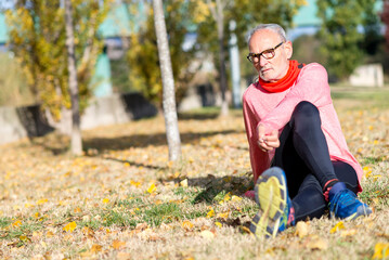 Senior man stretching on the grass during outdoor exercise