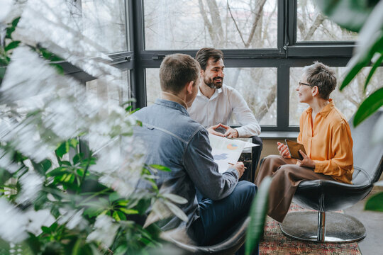 Smiling businessman having discussion with colleagues in office