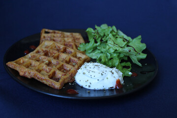 Savory waffles, with ham, grated cheese and grated carrot, served with white cheese, spicy red drops and balsamic green salad.