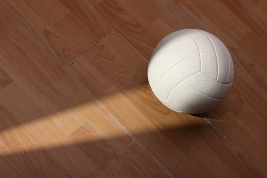 Volleyball on Wooden Court Floor Corner close up with light reflection with room for text or copy space