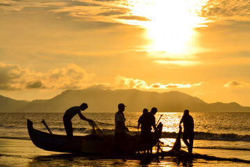 Fishermen Pulling Nets at Sunrise by the Shore