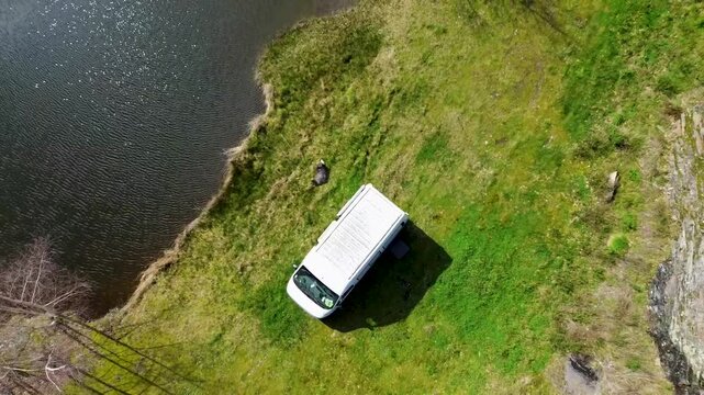 Nomade en fourgon am&eacute;nag&eacute; au bord d'un &eacute;tang vue drone