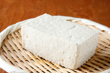 笊に盛った木綿豆腐　木目背景