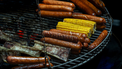 Sizzling sausages and sweet corn grilling over an open flame, creating a mouthwatering feast. Perfect for summer barbecues, this vibrant scene captures the essence of outdoor cooking and enjoyment.
