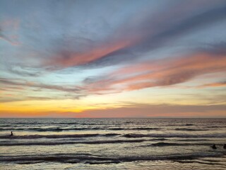 sunset over the tropical sea with soft waves and pastel clouds 