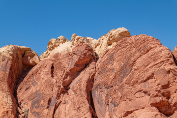 Obraz premium Desert varnish, red Aztec Sandstone outcrops. Rainbow Vista Trail, Valley of Fire State Park, Clark County, Nevada geology. Weathering joints
