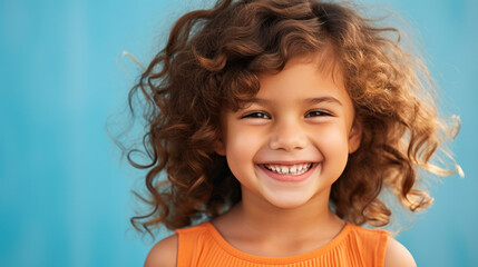 Smiling girl with curly hair on blue background