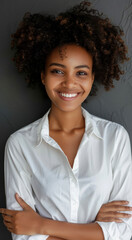 Confident woman smiling in white shirt against grey background