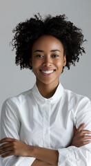 Confident woman smiling in white shirt against grey background