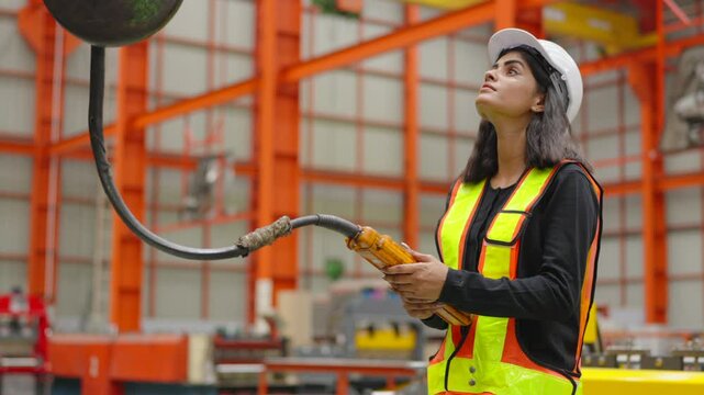 Worker or engineer operating remote switch to control machine in the factory