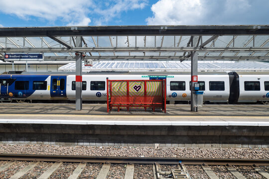 Bradford, UK 05 28 2025 Bradford Forster Square railway station with City of Culture branding platform seating. A blue and white Northern train can be seen waiting at a platform.