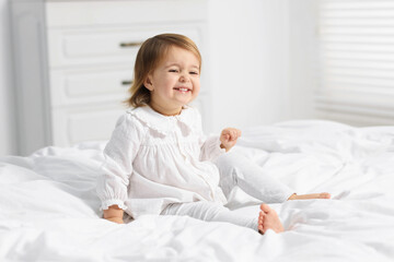 Fototapeta premium Cute little baby girl on bed at home