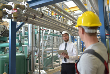 businessman and worker meeting in a factory - maintenance and repair of the industrial plant