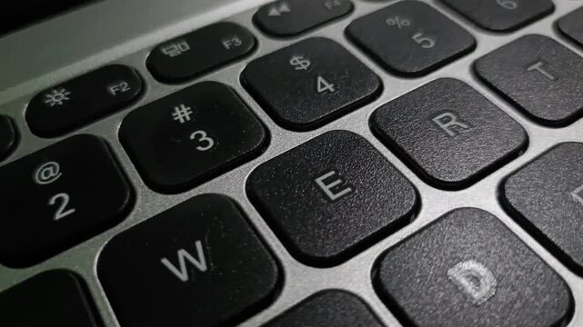 A close-up video of a QWERTY keyboard, showing detailed key layout and smooth typing motion. Ideal for tech, tutorial, and workspace content. Clean, modern view