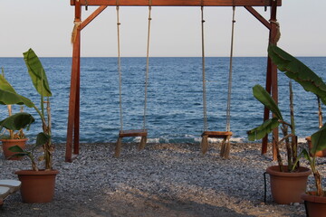Fototapeta premium swing on a beautiful sea coast, evening beach, mediterranean sea