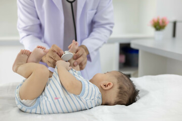Fototapeta premium The doctor examines the baby by holding and moving the baby in various positions, checking the baby's cries, and using a stethoscope to check the baby's internal symptoms.