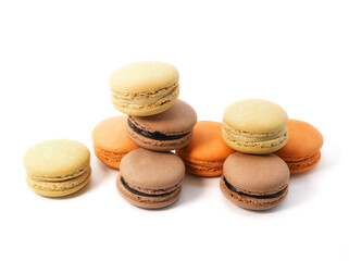Pile of macaron cookies in various flavours and colours isolated on white background.