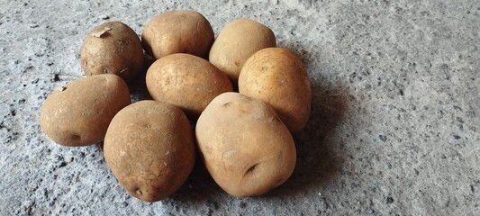 Overhead view of a group of freshly harvested raw potatoes, a staple food ingredient, resting on a...