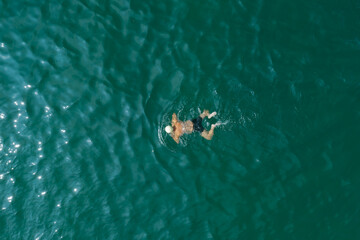 Aerial photography of people swimming in the sea, taken in Dalian, Liaoning Province, China
