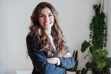 Businesswoman with arms crossed smiling at office