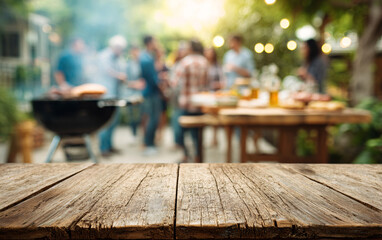 Wooden table surface with blurred outdoor barbecue party background and people gathering. Empty deck space for product display against social dining setting