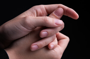 Close up of woman's hands intertwined together, delicate feminine hands with neat manicure. Support and touching herself