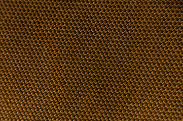Close-up texture of textile surface. Extreme macro close-up of synthetic fabric surface. Gold background in shallow depth of field