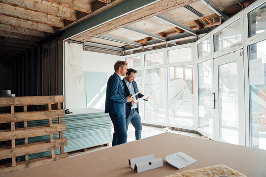 Two businessmen discussing energy efficiency at a construction site